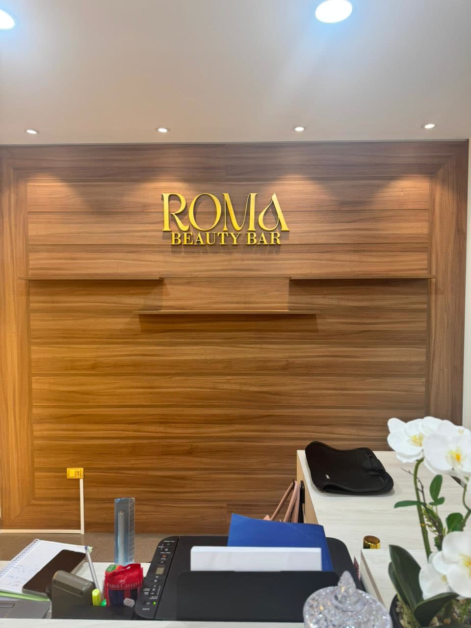Recepción con el logo de Roma en la pared de madera